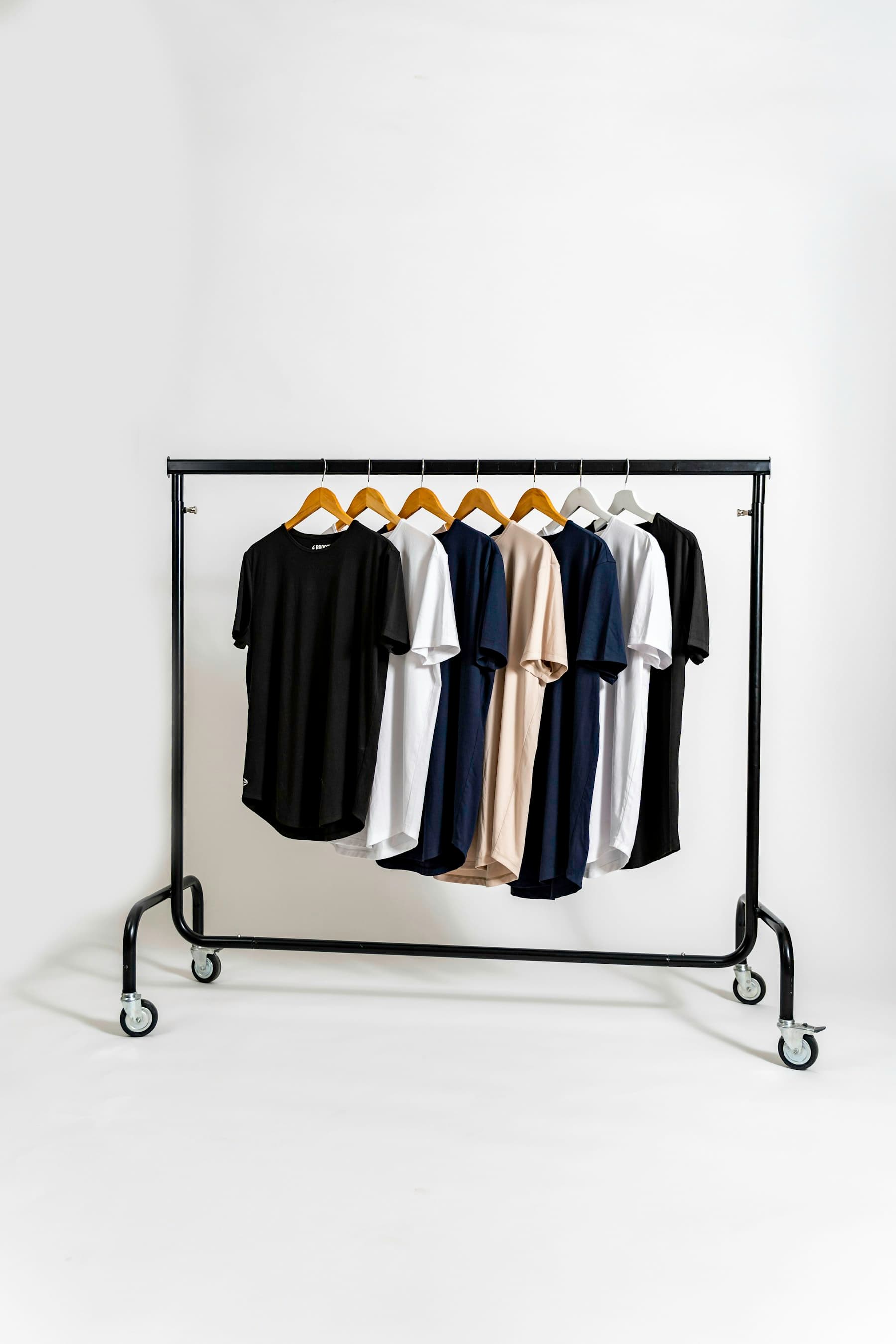 A rail of neutral outerwear in a bright studio.